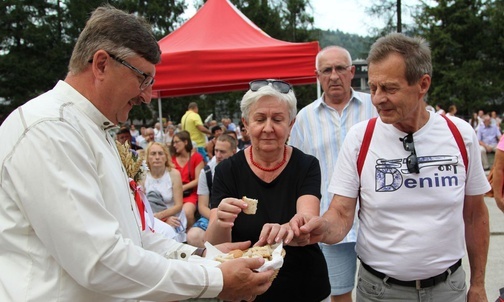 Wójt Brennej Jerzy Pilch częstuje uczestników dożynek chlebem z tegorocznej mąki.