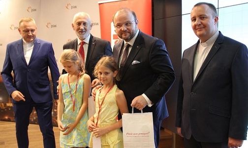 Przedstawicielki obdarowanych dzieci z darczyńcami z JSW i księżmi dyrektorami Caritas.