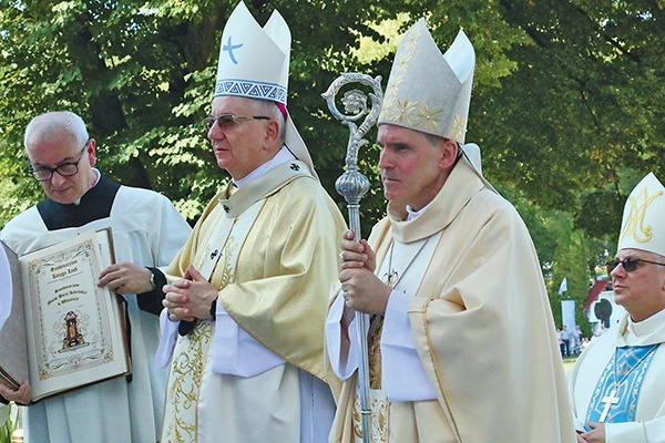 Bp Krzysztof Nitkiewicz, abp Stanisław Budzik i kustosz świątyni ks. Jerzy Ważny z księgą łask.