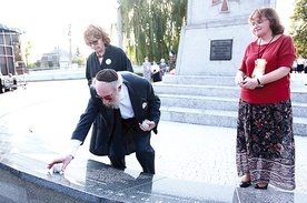 Jonathan Webber składa kamienie, zgodnie z żydowską tradycją, na tablicach pamięci przy borzęcińskim pomniku poległych.