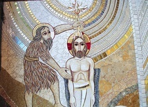 Jezus przyjmuje chrzest z rąk Jana. Jest tu przedstawiony w biernej postawie na znak, że jest całkowicie poddany woli Ojca w Duchu Świętym.