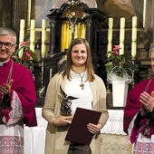 ▲	Małgorzata Białczak  ze statuetką i gratulujący jej wyróżnienia księża: Jan Krajczyński  (od lewej) i Wiesław Gutowski.