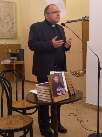 Ks. Waldemar Bożek prezentuje swoją książkę.