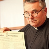 	Ksiądz proboszcz Jacek Gołębiowski z historycznym dokumentem bractwa eucharystycznego. 