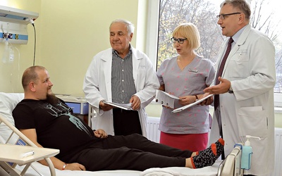 Od lewej: prof. Lech Poloński, oddziałowa Krystyna Czapla i prof. Mariusz Gąsior w rozmowie z pacjentem.