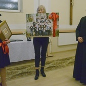 Ks. Daniel Glibowski otrzymał fotografię wolontariuszy, wykonaną przy altanie w parku Kościuszki. Z lewej Marta Pawelczyk.