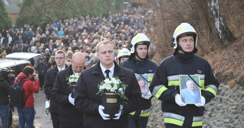 Strażacy nieśli w kondukcie fotografie zmarłych, tuż przy urnach z ich prochami.