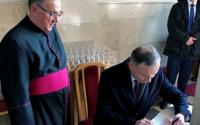 Prezydent wpisał się do księgi pamiątkowej sanktuarium. Obok ks. Jerzy Karbownik, kustosz sanktuarium.