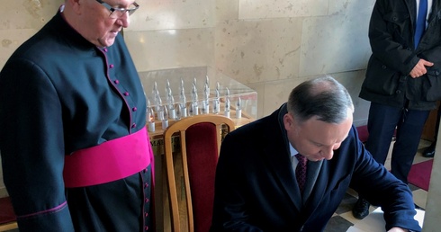 Prezydent wpisał się do księgi pamiątkowej sanktuarium. Obok ks. Jerzy Karbownik, kustosz sanktuarium.