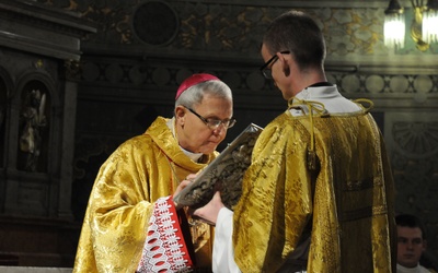 Bp Piotr całuje księgę Ewangelii w czasie liturgii.