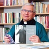 Ksiądz profesor prezentujący swoje publikacje.