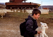 Albański chłopiec niesie baranka tuż przy zniszczonym serbskim czołgu w Kosowie.
22.03.2019 Fushtica, Kosowo