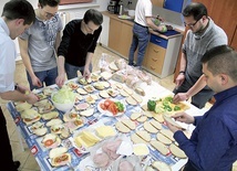 ▲	W siedzibie DA „Centrum” przy ul. Powstańców 21 młodzi z ks. Krzysztofem Nowrotem (z lewej) przygotowują posiłek  dla potrzebujących.
