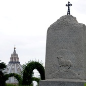 Kamienny monument przypominający o krzyżu na Giewoncie, ustawiony w Ogrodach Watykańskich z woli św. Jana Pawła II w 2001 r. W tle kopuła bazyliki św. Piotra.