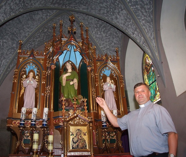 Ksiądz Kuzak pokazuje ołtarz z figurą św. Tekli.