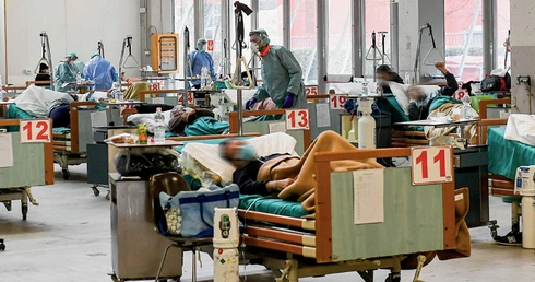 Lekarze, pielęgniarki i inni pracownicy szpitali z narażeniem życia niosą pomoc osobom chorującym z powodu COVID-19.