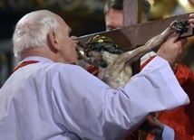Bp Ignacy Dec całujący ramiona wiszącego na krzyżu Chrystusa.