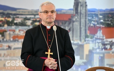 Biskup Marek Mendyk na tle świdnickiej katedry.