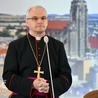 Biskup Marek Mendyk na tle świdnickiej katedry.
