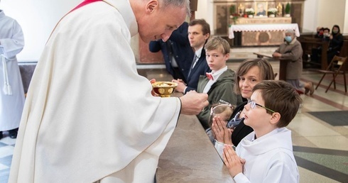 Bp. Marek Solarczyk udziela Komunii św. Michałowi