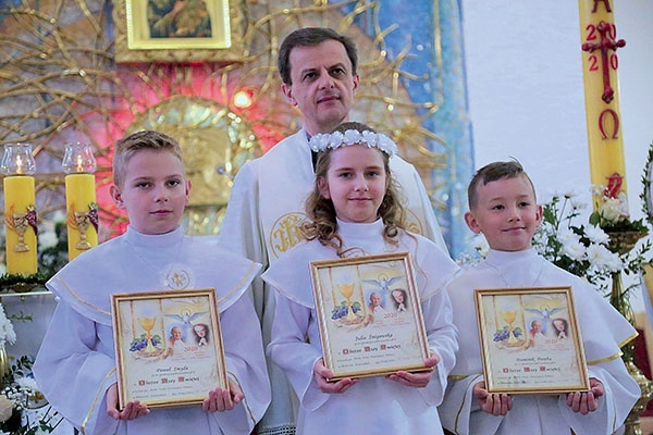 Pawel, Julia i Dominik z ks. Rafałem Porębą.