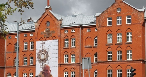 W Koszalinie zawisł ogromny baner z wizerunkiem św. Jana Pawła II. Ma budzić głód Eucharystii.