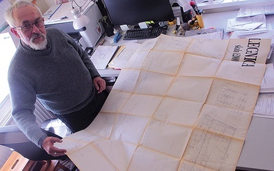 Pan Jerzy w swojej pracowni pokazuje oryginalne plany umiejscowienia konstrukcji ołtarzowej na legnickim lotnisku.