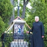 ▲	Ks. Wojciech Marchewka przy krzyżu, gdzie umieszczono wizerunek świętej.