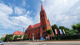 Przed świątynią stoi kamienny krzyż misyjny.