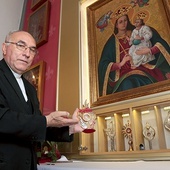 ◄	Ks. prał. Antoni Koterla z relikwiami bł. ks. Jerzego przy obrazie MB Pocieszenia.