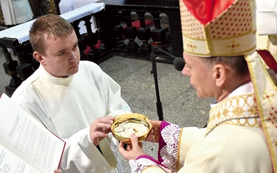 Nowy akolita otrzymuje od biskupa patenę.