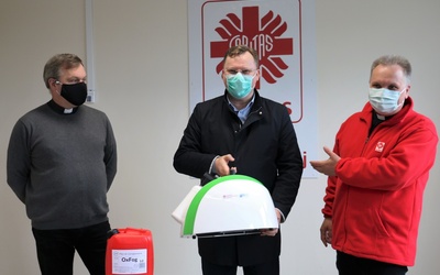 W siedzibie diecezjalnej Caritas ks. Szymon Pikus (z lewej) i ks. Robert Kowalski, dyrektor Caritas Diecezji Radomskiej, przekazali fumigator Julianowi Wróblowi, dyrektorowi przysuskiego szpitala.