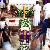Żałobnicy przechodzą obok trumny podczas Mszy.