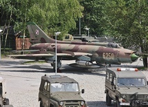 Samolot myśliwsko--bombowy SU-22 w otoczeniu specjalistycznych samochodów.
