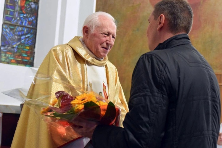 Ks. Jan Pryszczewski odbierający kwiaty z rąk zaproszonych gości.