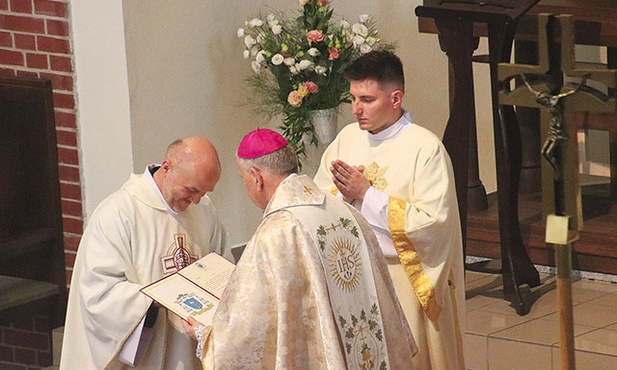 Biskup Jan Kopiec przekazuje proboszczowi o. Robertowi Więckowi SJ dekret ustanawiający diecezjalne sanktuarium.