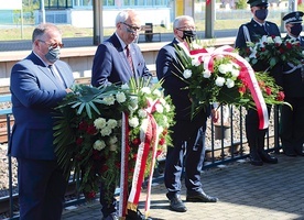 ▲	Złożenie kwiatów pod tablicą pamiątkową na peronie kolejowym.