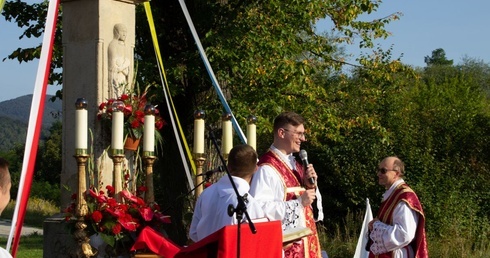 Ks. Marcin Hałas przy ołtarzu ustawionym przed XIX-wiecznym krzyżem na os. Langiewicza.