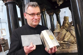 Ks. Piotr Filas SDS trzyma relikwie świętej niespodziewanie odnalezione w sarkofagu w marcu tego roku.