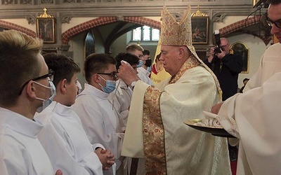 Biskup nakładał nowym lektorom symbol ich służby.