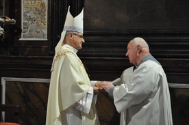 Biskup gratulujący stażu pracy katedralnemu kościelnemu.