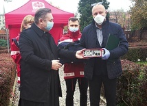 Na zdjęciu ks. D. Amrogowicz symbolicznie przekazuje urządzenie Andrzejowi Sztanderze.