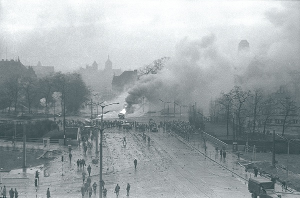 Walki uliczne w rejonie Huciska w Gdańsku 15 grudnia 1970 roku. W tle kościoły św. Mikołaja, św. Jana i Mariacki.