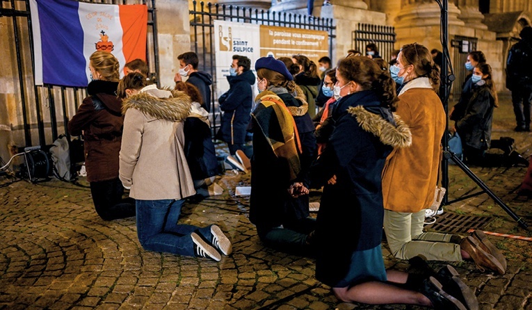 Katolicy modlący się przed zamkniętym z powodu epidemicznych obostrzeń kościołem pw. św. Sulpicjusza w Paryżu.