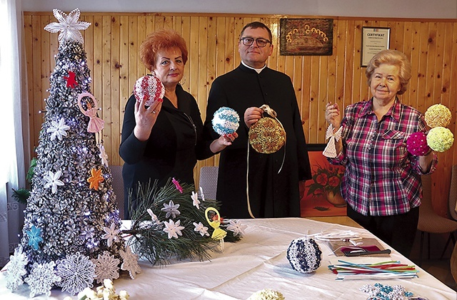 	Panie Genowefa (z prawej) i Marianna z ks. Gabrielem Marciniakiem prezentują świąteczne ozdoby.