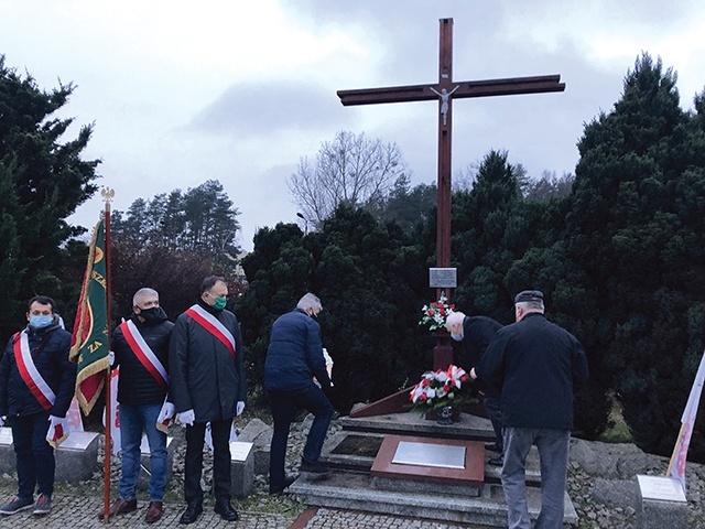 Przedstawiciele hutniczej Solidarności składają wieniec przed krzyżem.