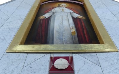 Papieska piuska pod obrazem św. Jana Pawła II w prezbiterium.