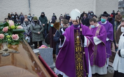 Biskup wraz ze zgromadzonymi nad grobem żałobnikami.