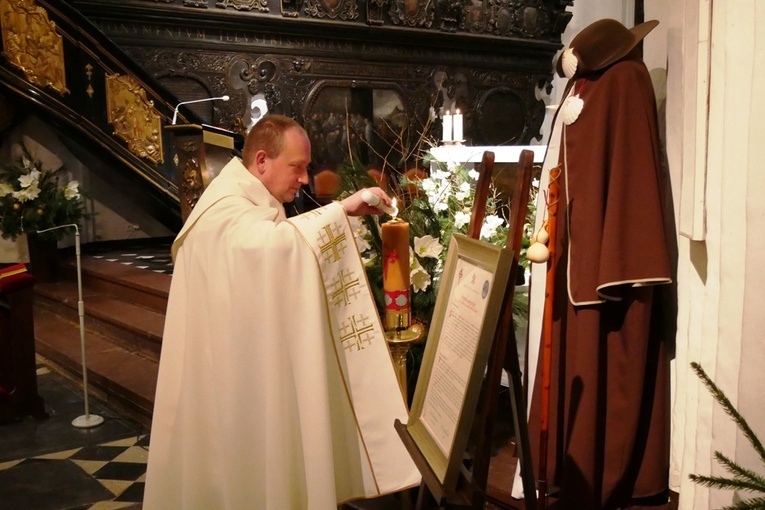 Ks. kan. Krystian Kletkiewicz, proboszcz archikatedry oliwskiej, zapala jubileuszową świecę.