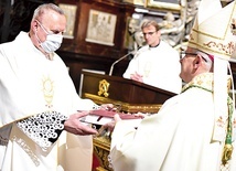 Biskup otrzymaną księgę intencji i podziękowań przekazał proboszczowi.